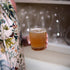 Hand holding a Stone DOF glass filled with a cocktail on a colorful dress background