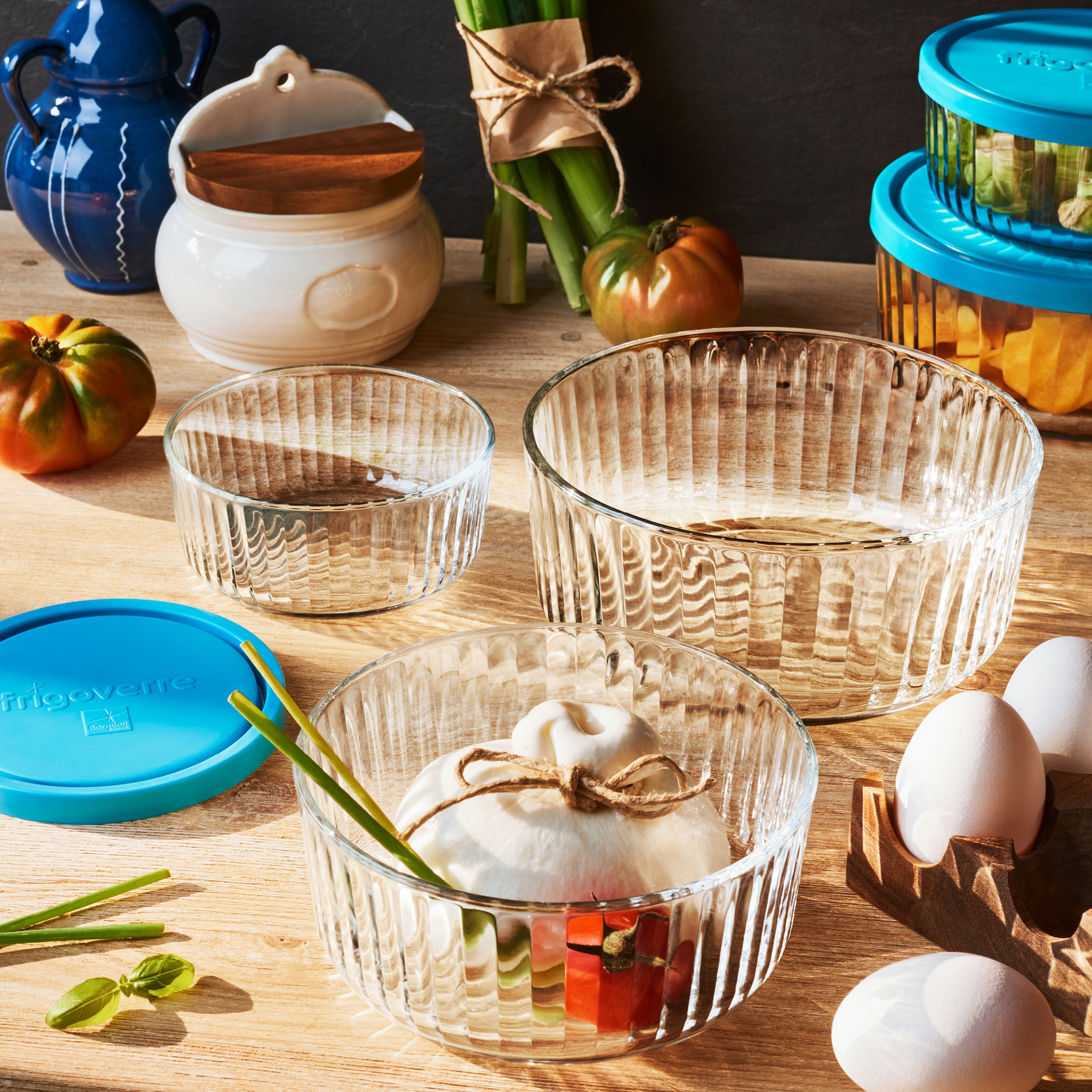 Clear Frigoverre Brillante glass bowls with decorative items on a wooden table.