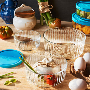 Clear Frigoverre Brillante glass bowls with decorative items on a wooden table.