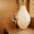 Clear InAlto Uno Medium wine glass and white vase with dried plants on a wooden surface