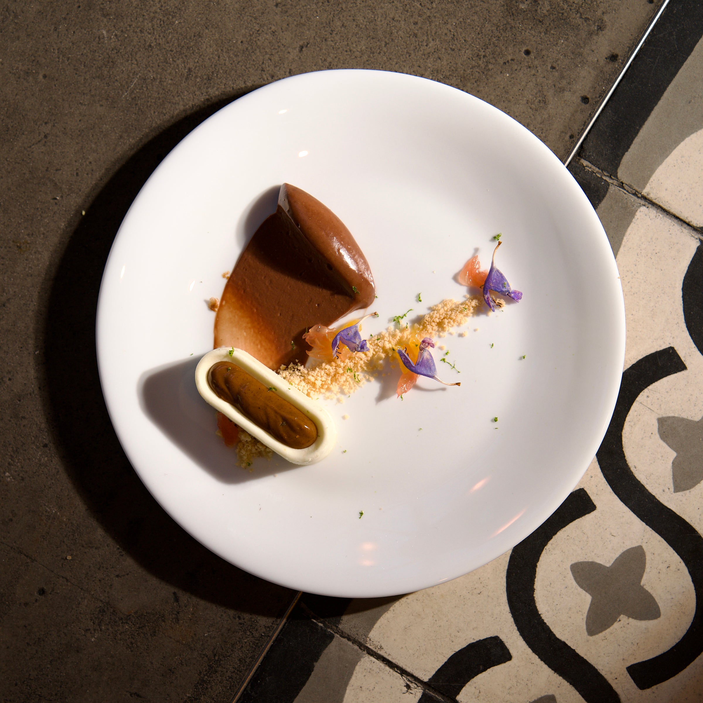 Delicate dessert presentation on a white plate with a dark background